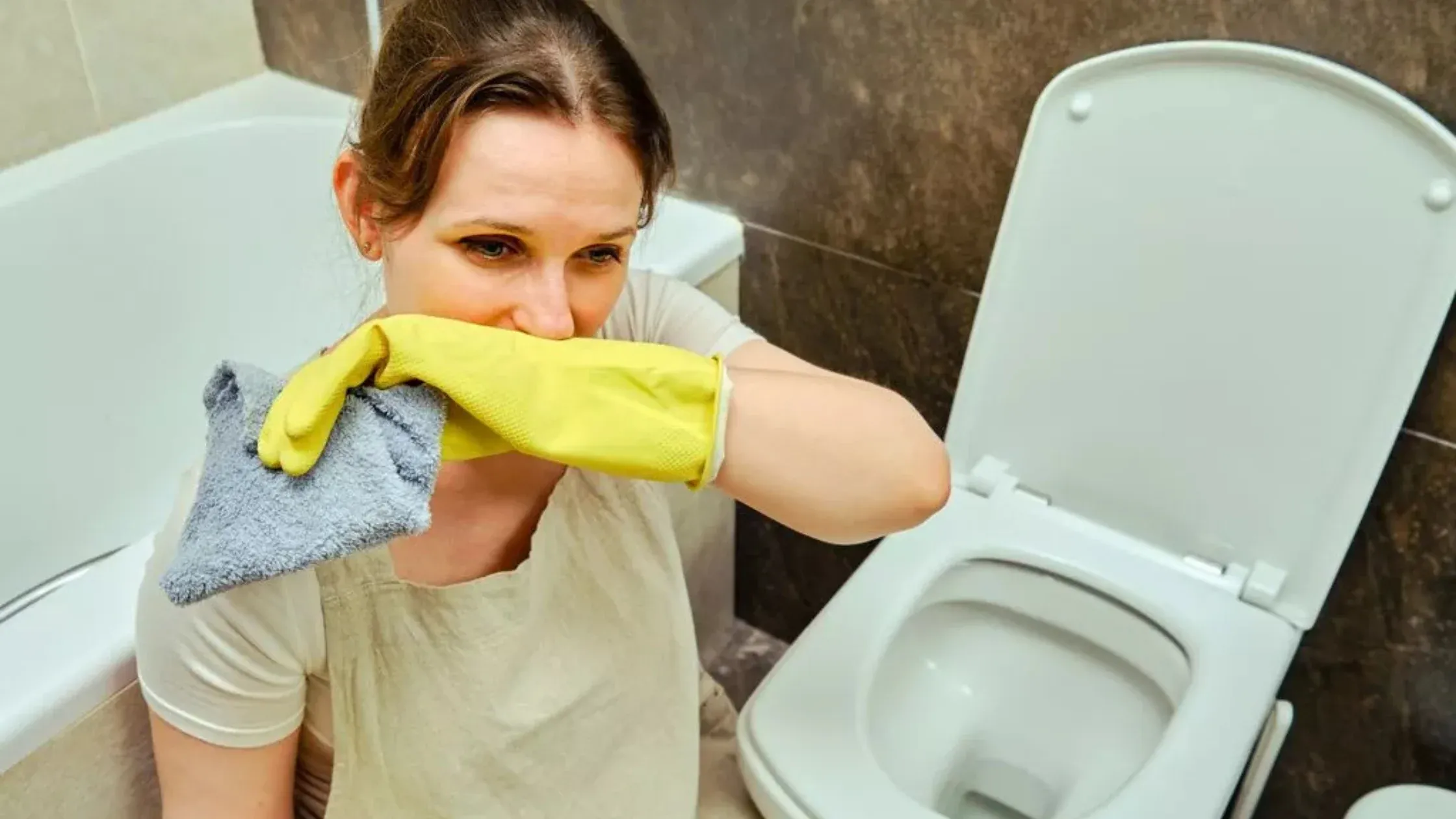 Woman covering nose and thinking How to Diagnose the Source of Rotten Egg Smell in My Bathroom?